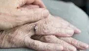Eine Person hält die Hände einer älteren Person