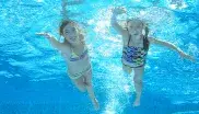 Schwimmende Kinder unter Wasser